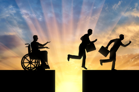 The silhouette of a disabled worker in a wheelchair stopped before an abyss and healthy workers jump over the abyss and run on. The concept of inequality of people with disabilitiesの写真素材