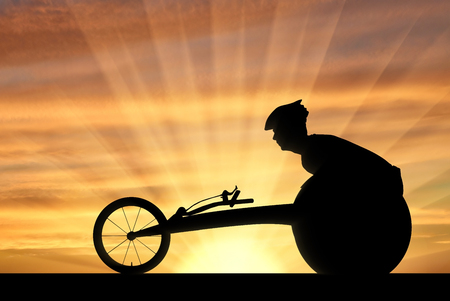 Silhouette of sportsman disabled in a racing wheelchair. The concept of disabled sportsmenの写真素材