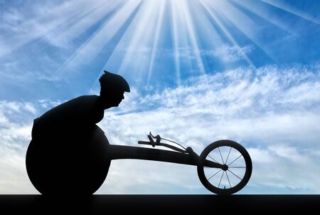 Silhouette of sportsman disabled in a racing wheelchair. The concept of disabled sportsmenの写真素材