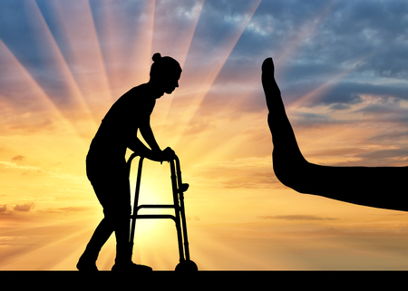 Silhouette of a woman with a walker for disabled and hand gesture stop. The concept of discrimination and disrespect for people with disabilities and old ageの写真素材