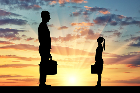 Silhouette of workers, a big man and a small woman. The concept of gender inequality in a careerの写真素材