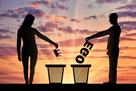Silhouettes of men and women who throw into the urn the crown and the word of the ego. The concept of selfishness and narcissism as a problem in societyの写真素材