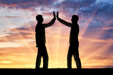 Silhouette of men make a gesture, give five. The concept of mutual benefitの写真素材