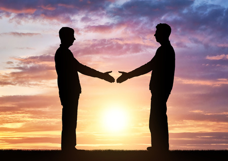 Silhouette two men intend to shake hands. Business concept of business relationsの写真素材