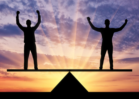 Silhouette two men are equal standing on the scales. Business concept of equal mutual benefitの写真素材