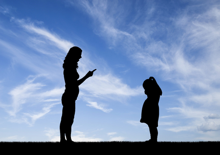 Silhouette, little sad crying girl child and the mother screaming at her. A conceptual depiction of child abuseの写真素材