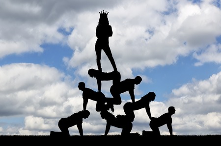 Silhouette narcissistic egoist woman with a crown on his head standing on humans. The concept of selfishness and narcissismの写真素材