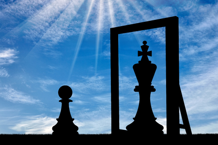Silhouette of a narcissistic pawn, sees himself in the reflection of the mirror queen. The concept of narcissismの写真素材