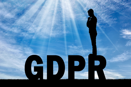 Silhouette pensive man standing on the word GDPR. Conceptual image about the law GDPRの写真素材