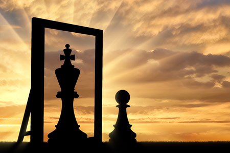 Silhouette of a pawn, sees himself in the reflection of the mirror queen. The concept of narcissism and egoの写真素材