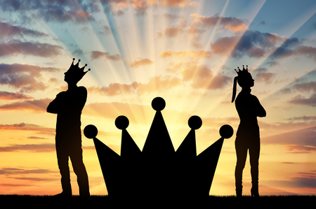 A big crown between a selfish man and a woman with a crown on her head, they stand with their backs to each other. Concept of selfishness in societyの写真素材