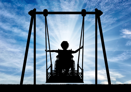 Lifestyle of children with disabilities. Happy child is disabled in a wheelchair on an adaptive swing for disabled children.の写真素材