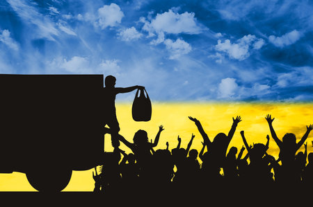 Humanitarian aid and crisis in Ukraine. The silhouette of a military man distributing humanitarian aid to people against the background of the sky in the form of the flag of Ukraine.の写真素材