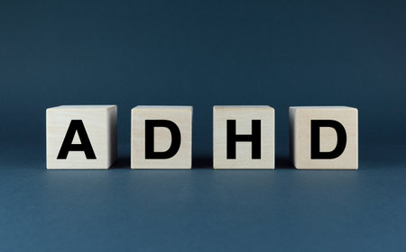 Wooden blocks spelling out ADHD, a common childhood disorder. This image is perfect for raising awareness about ADHD and its impact on childrenの写真素材
