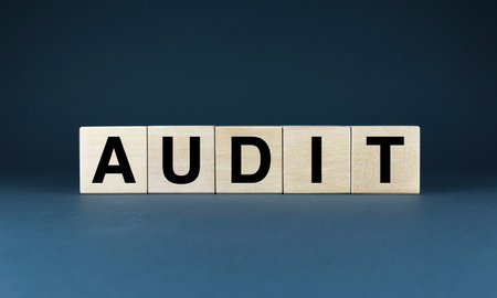 Wooden blocks spelling out the word AUDIT. This image represents the successful completion of a thorough audit, providing a strong foundation for business growth and investor confidenceの写真素材