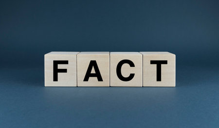 A conceptual image representing the significance of facts in our understanding of the world. The word 'FACT' spelled out in wooden blocks symbolizes the building blocks of knowledge and truthの写真素材