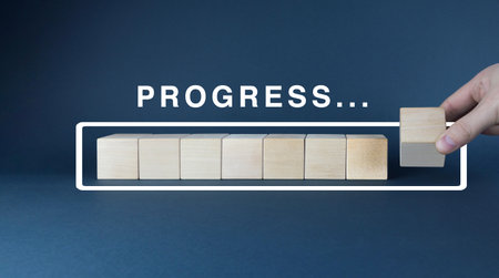 A focused image suggesting the idea of finishing a task or project. The wooden blocks create a visual representation of a completed progress bar, symbolizing the achievement of a goalの写真素材