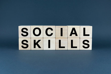 A closeup of wooden blocks spelling the word SOCIAL SKILLS. This image represents the concept of interpersonal relationships, communication, and social interaction. It can be used for educational, psychological, or business purposesの写真素材