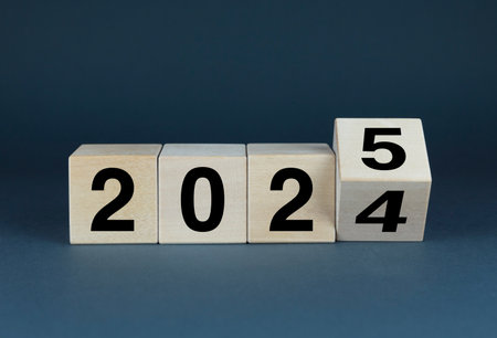 A close-up of wooden blocks with the numbers 2024-2025, suggesting a countdown to the new year. The...