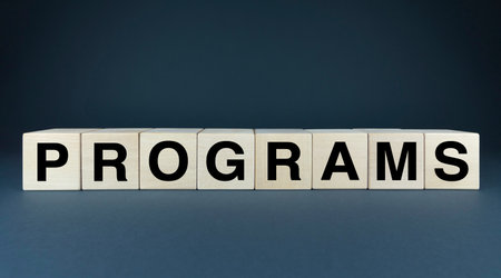 Wooden blocks spelling PROGRAMS. This image symbolizes educational programs, courses, process of planning and organizing events, projects, or tasks, software programs, coding, and computer applications.の写真素材