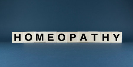 Word HOMEOPATHY spelled out in wooden blocks, representing a form of alternative medicine. This image can be used to illustrate the concept of complementary and alternative medicineの写真素材