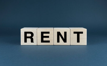 A set of wooden blocks spelling out the word RENT against a dark blue background. The image is a concept for rental, leasing, or real estateの写真素材
