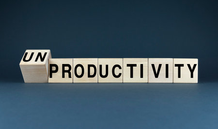 A conceptual image featuring wooden blocks spelling out the words productivity and unproductivity. The image symbolizes the constant struggle between efficiency and procrastination, and the importance of finding a balance between work and restの写真素材
