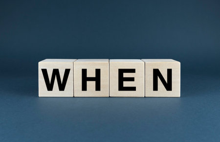 Wooden blocks spelling out the word WHEN against a clean, white background. Perfect for presentations, websites, or any project related to time management, planning, and schedulingの写真素材