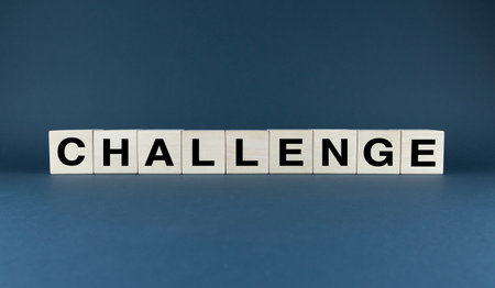 Wooden blocks spelling out the word CHALLENGE. This image can symbolize overcoming obstacles, personal growth, and the pursuit of goalsの写真素材