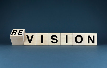 Wooden blocks spelling out Vision and Revision, suggesting that ideas are constantly evolving and being refined. Concept creativity, innovation, and the importance of a flexible mindsetの写真素材