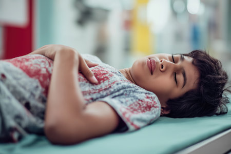 A young child lies deeply asleep on an examination table in a clinic, a sign of the severity of their child heart disease and a recent episode of extreme chest pain.の素材