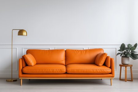A minimalist contemporary living room with a striking orange leather sofa. The decor includes a golden floor lamp and a small plant on a wooden stool.の素材