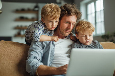 A single father looks intently at a laptop screen with his two young sons, seeking medical guidance for one of the children through a telehealth service.の素材
