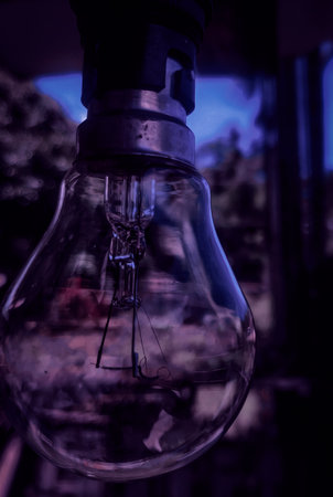 A closeup shot of a light bulb in a dark room with blurred background