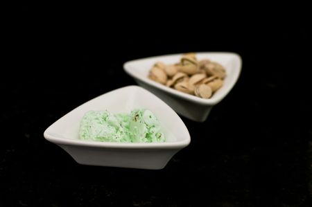 Small dish of pistachio ice cream with dish of pistachiosの写真素材