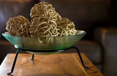 A centerpiece of wicker balls in a comfortable, leather sitting room with soft lightingの写真素材