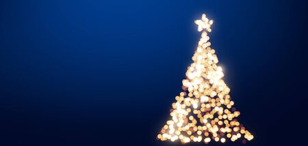 A shining blurred Christmas tree in front of a blue background.