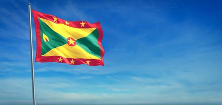 The National flag of Grenada blowing in the wind in front of a clear blue skyの写真素材