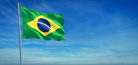 The National flag of Brazil blowing in the wind in front of a clear blue sky