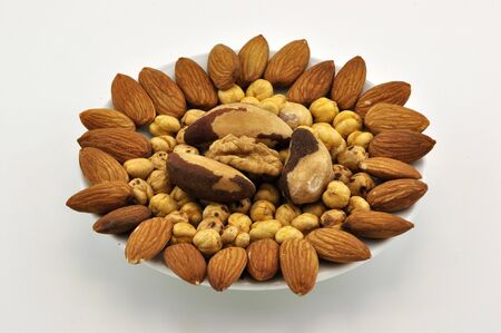 Mixed nuts on white plateの写真素材