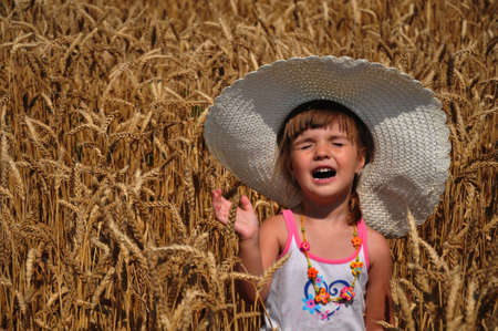 a beautiful little girl with a bonnet in the Ryeの写真素材