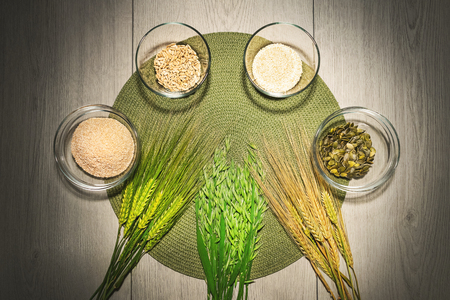 Mix of different kinds of flour in the bowls with fresh wheat and barley grains.の写真素材