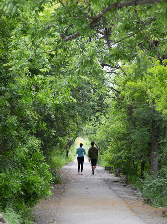 Couple on walking path with tree canopyの写真素材
