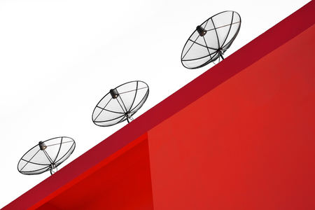 Satellite dish on the roof of the red building.の写真素材