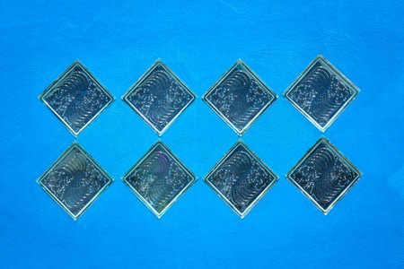 Translucent glass on blue plaster wall.の写真素材