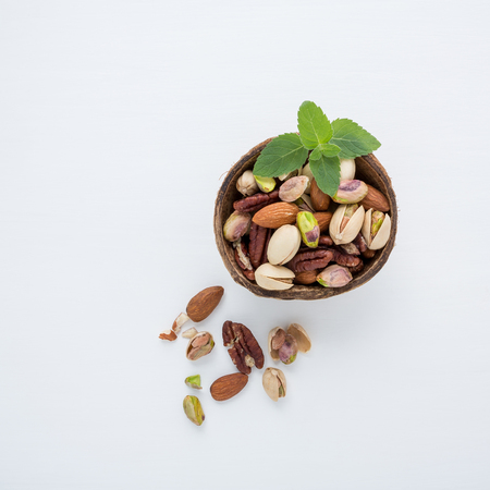 Almond, pecan ,pistachios, in bowls on white wooden background.の写真素材