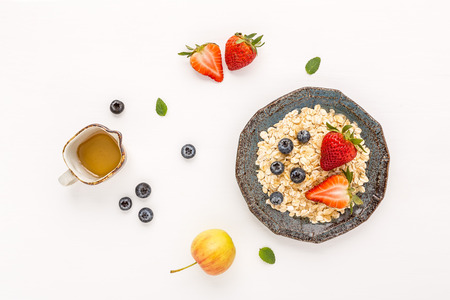 Healthy breakfast with muesli, fruits, berries on wooden white background.の写真素材