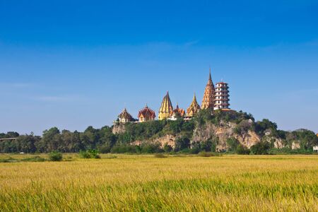 Wat Tham Sua and Wat Tham Khao Noi with rice fields in the foregroundの写真素材