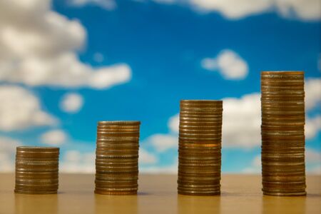 Coin stacks with blue sky backgroundの写真素材