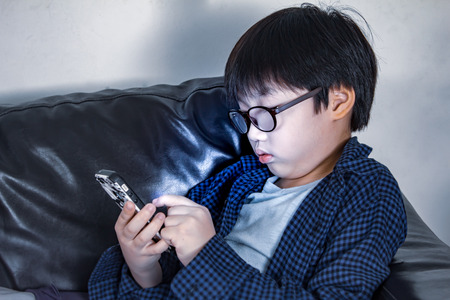 the boy playing game with mobile phoneの写真素材